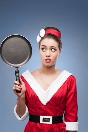 young cheerful retro girl in red vintage dress holding frying panの写真素材