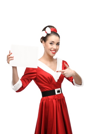 cheerful young caucasian woman in red vintage clothing holding and pointing at sign isolated on whiteの写真素材
