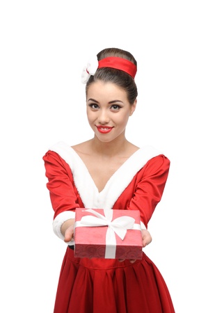 cheerful young caucasian woman in red vintage clothing holding red christmas gift isolated on whiteの写真素材