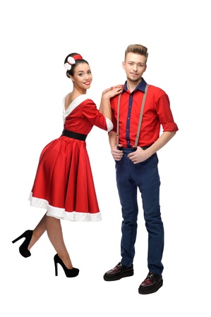 cheerful young caucasian couple in red vintage clothing standing isolated on whiteの写真素材