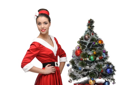 young cheerful retro girl standing near christmas tree isolated on whiteの写真素材