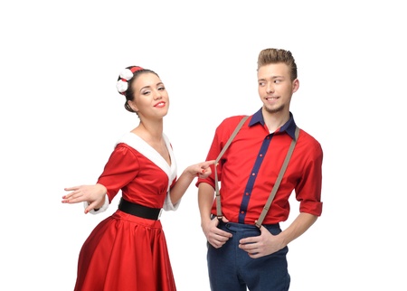 cheerful young caucasian couple in red vintage clothing standing isolated on whiteの写真素材