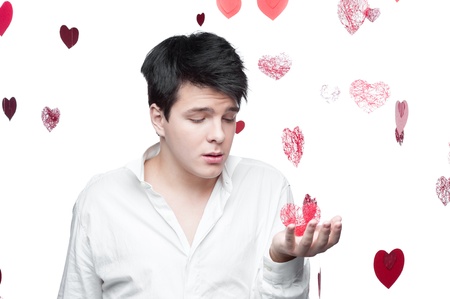 young caucasian brunette man in white shirt standing with gentle expression over red flying hearts...