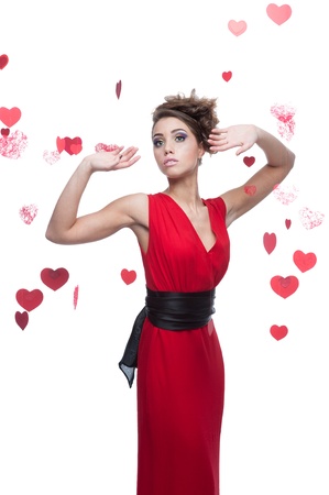 woman in red dress posing over red hearts backgroundの写真素材