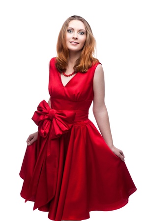 cheerful young woman in red dress standing  isolated on whiteの写真素材