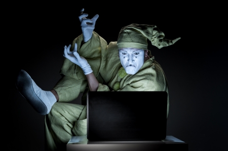 funny mime sitting near laptop and show agressive expressionの写真素材