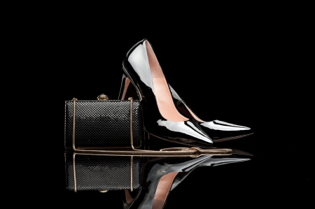 composition of black female high heel shoes and clutch isolated on blackの写真素材