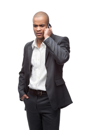 young worried black businessman talking on cell phone isolated on whiteの写真素材