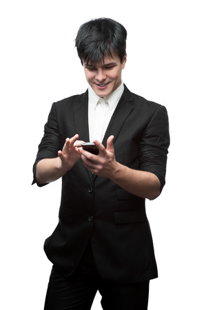 young smiling caucasian brunette businessman isolated on white background using cell phoneの写真素材