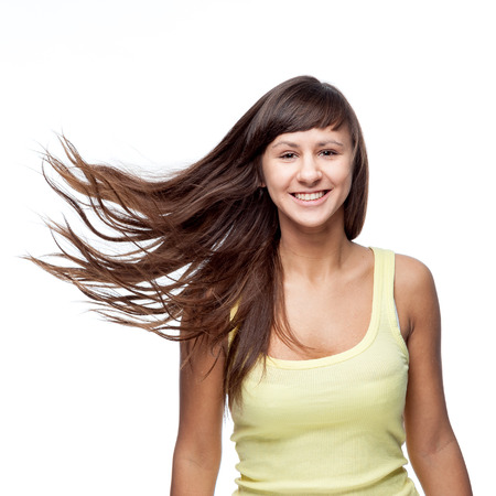 attractive caucasian smiling girl with blowing hair  isolated on whiteの写真素材