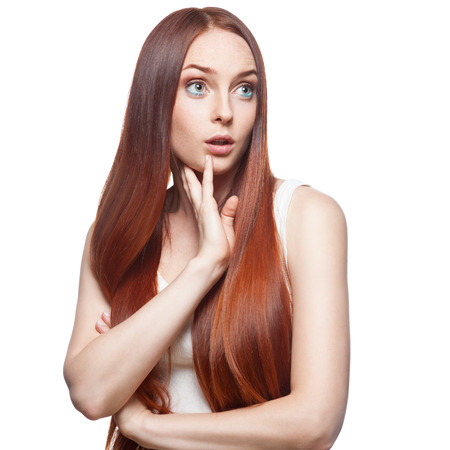 attractive casual surprised caucasian red haired young woman isolated on whiteの写真素材