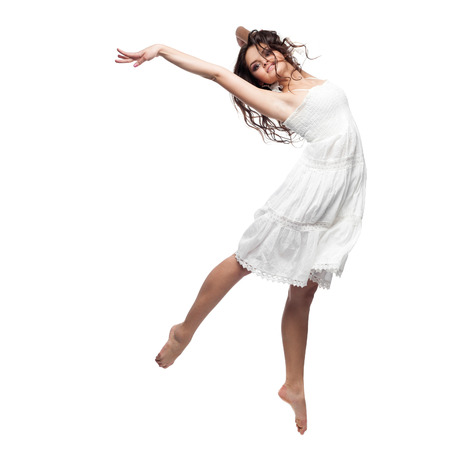 beautiful caucasian brunette woman in white dress dancing isolated on white backgroundの写真素材