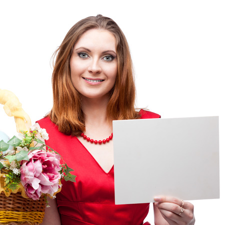 cheerful young woman in red dress holding easter basket and sign isolated on whiteの写真素材