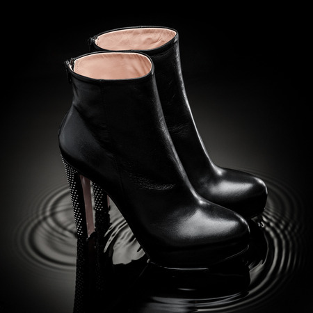 black  leather female high heel boots standing in shaking waterの写真素材