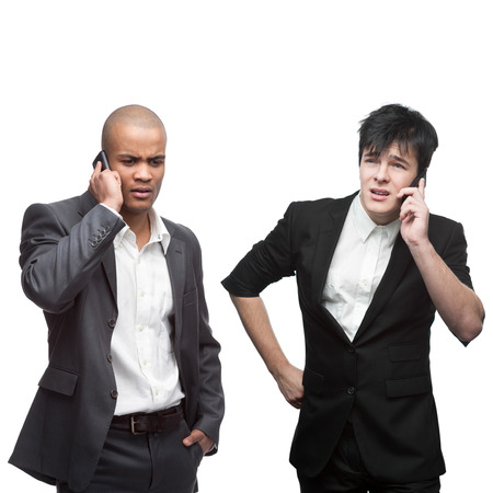 two strained businessman calling by mobile telephone isolated on whiteの写真素材