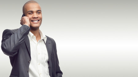 successful young african businessman standing over gray background