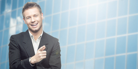 successful young businessman standing over blue backgroundの写真素材