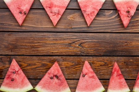 ripe watermelon slices on dark old wooden background top viewの写真素材