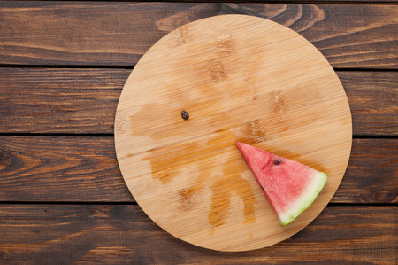 ripe watermelon slice on dark old wooden background top viewの写真素材
