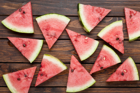 ripe watermelon slices on dark old wooden background top viewの写真素材
