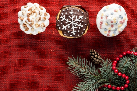 christmas decorated cupcakes on red burlap background top viewの写真素材