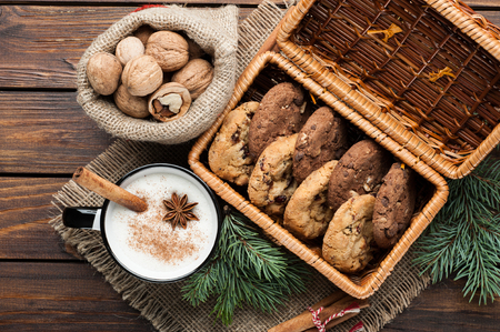 eggnog cocktail in a mug arranged with christmas decoration and cookies box on wooden tableの写真素材