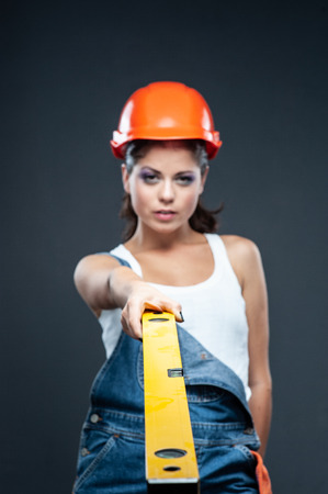 Attractive young woman doing repairs at home. Portrait of a female construction worker. Building, repair concept.の写真素材