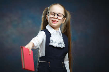 Young Schoolgirl Pass Hold Book Wink with one Eyeの写真素材