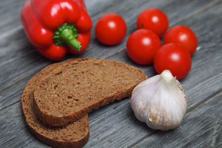 bread and vegetables. pepper tomato cherry and garlic on wooden table. fresh food