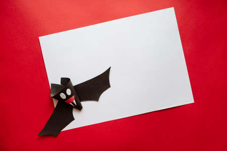 Funny Halloween Bat Made From Paper on a Red Background. Postcard on Helloween.の写真素材