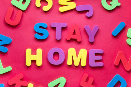 Coronavirus, COVID-19, Self-quarantine, Isolation, Social Disdancing Concept. Text STAYHOME Made With the Letters Of The Alphabet In Different Colors On a Red Backgroundの写真素材