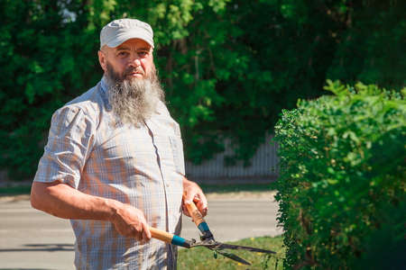 Portrait Gardener Man with gardening scissors near hedgerow.の写真素材