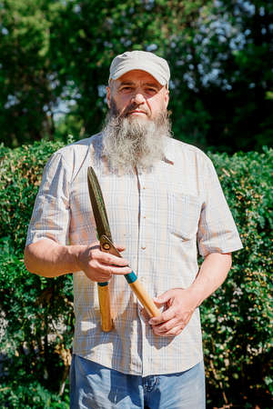 Portrait Gardener Man with gardening scissors near hedgerow.の写真素材