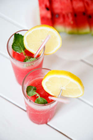 fresh sliced watermelon and watermelon smoothie on a wooden table. Selective focus