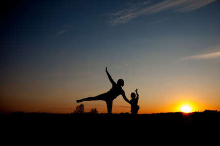 Mother and daughter playing at the sunset time. Concept of friendly family.の写真素材