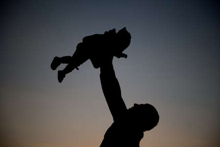 Father and child playing the sunset time. Concept of friendly family.
