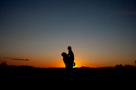 Happy Father holding baby on sunsetの写真素材