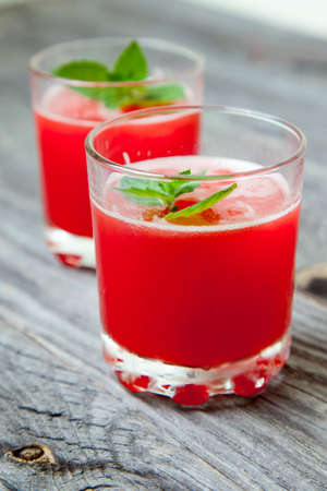 two glasses of watermelon juice with mint on wooden backgroundの写真素材
