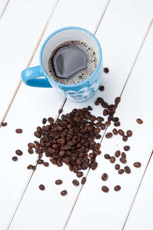 Cup of coffe and beans on white wooden tableの写真素材