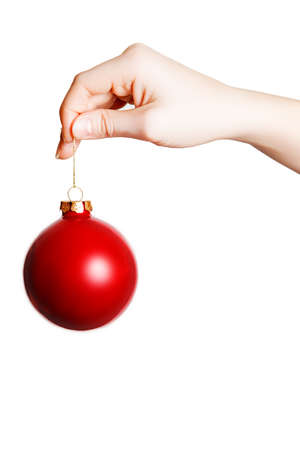 Woman's hand holding a Christmas ball on a white backgroundの写真素材