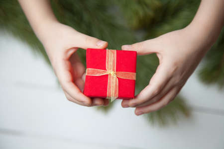 holidays, present, childhood and happiness concept - close up of child hands with gift box over...