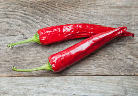 Red chili peppers on a wooden tableの写真素材