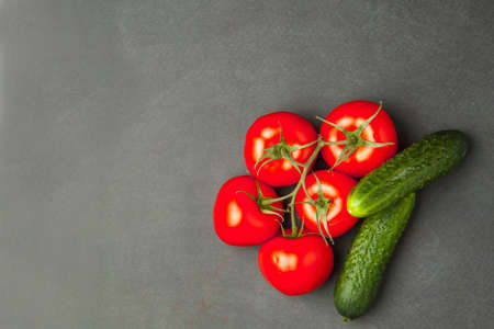 tomatoes and cucumbers and on a dark background. food concept. Empty space for text. Top view.の写真素材