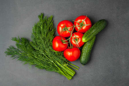 Background of blank black color with fresh healthy vegetables - cucumber, dill and tomatoes. Top view.の写真素材