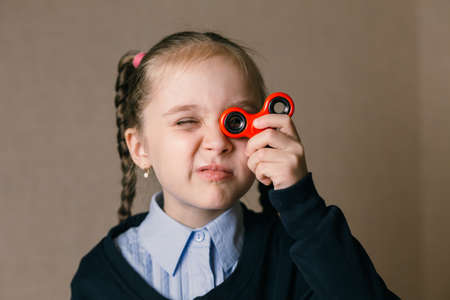 Little caucasian girl with Fidget Spinner held up to his eyesの写真素材