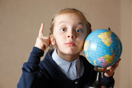 Little girl with a globe showing a thumb up - IDEAの写真素材