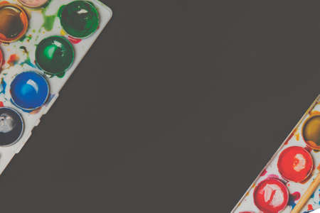 Old used watercolor paint box top down view. frame on dark backgroundの写真素材