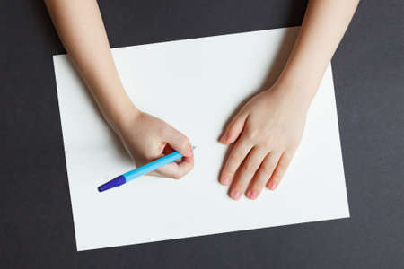 Hand of a child writing on white paperの写真素材