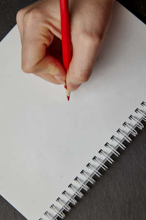 hand writing on notebook with wood pencil