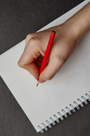 hand writing on notebook with wood pencil